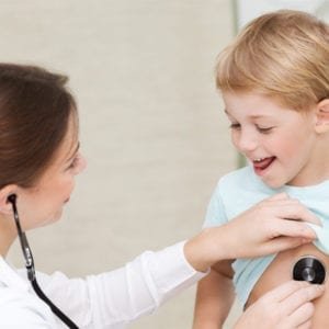 A woman carefully diagnosing baby's chest for medical assessment.