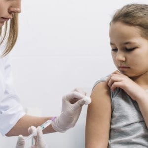 The image depicts a healthcare professional administering a vaccine to a patient.